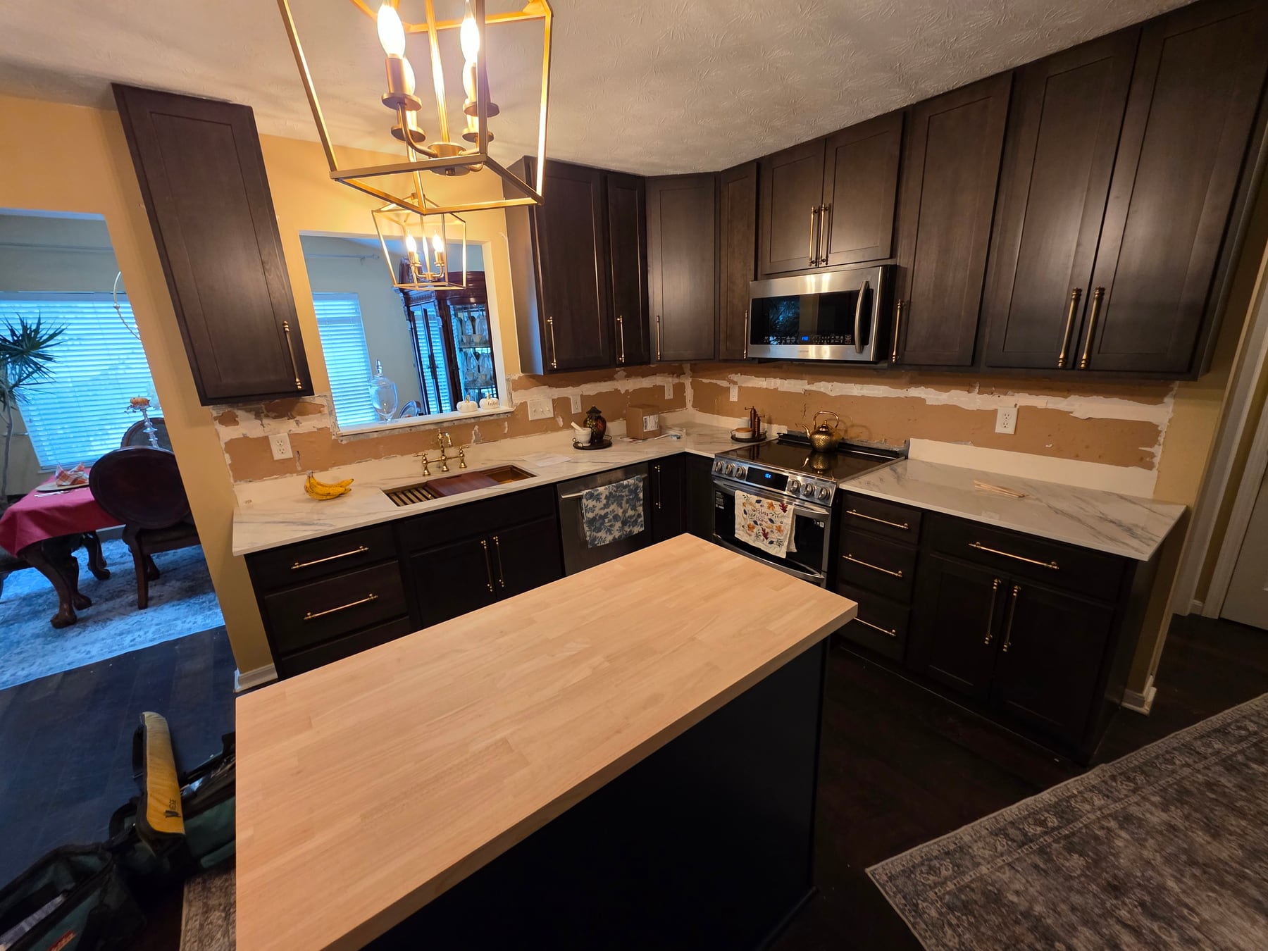 Completed K4 kitchen scope with dark cabinetry, light counters, and a blue island