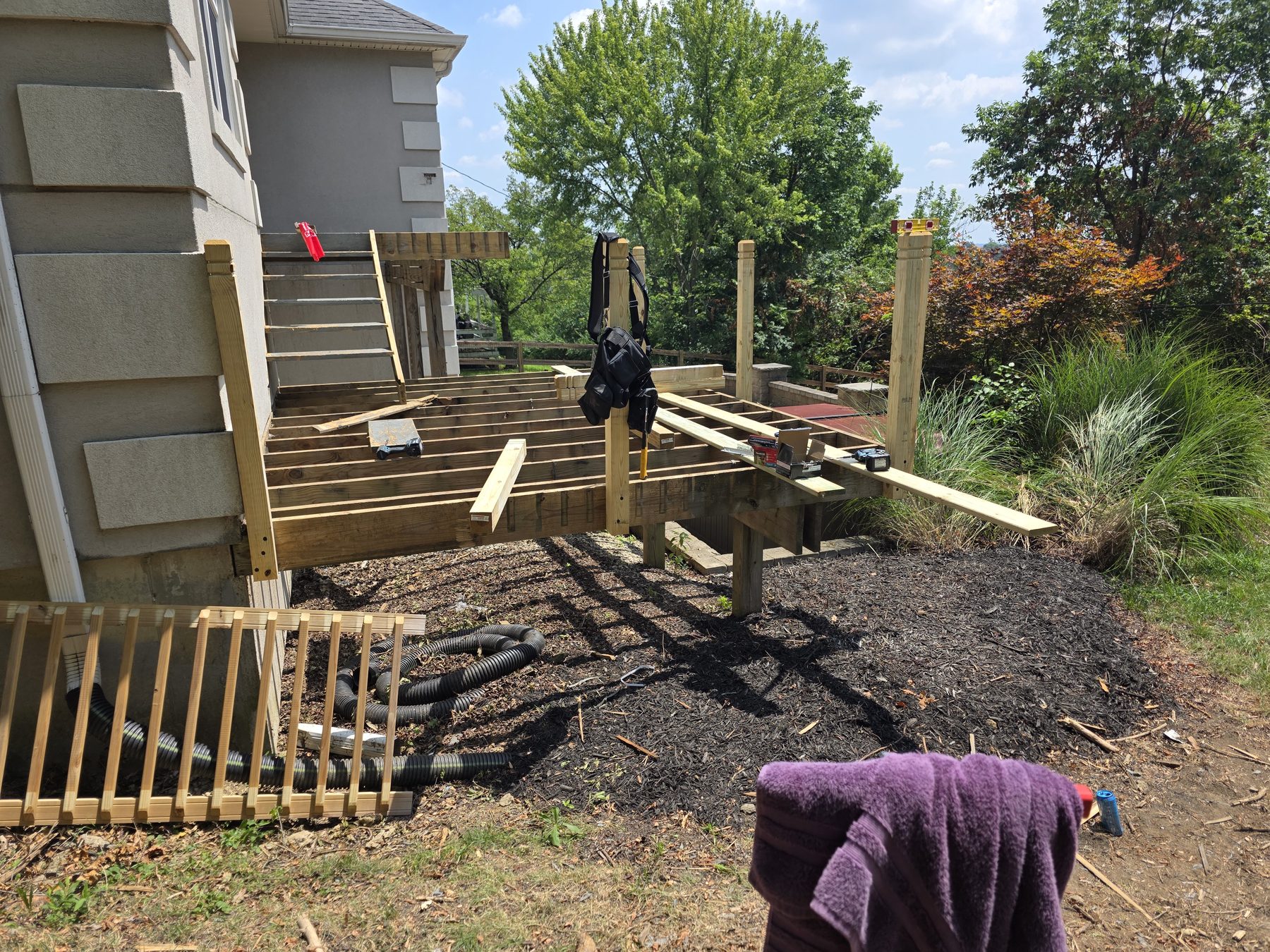 Deck during demolition with boards and railings removed