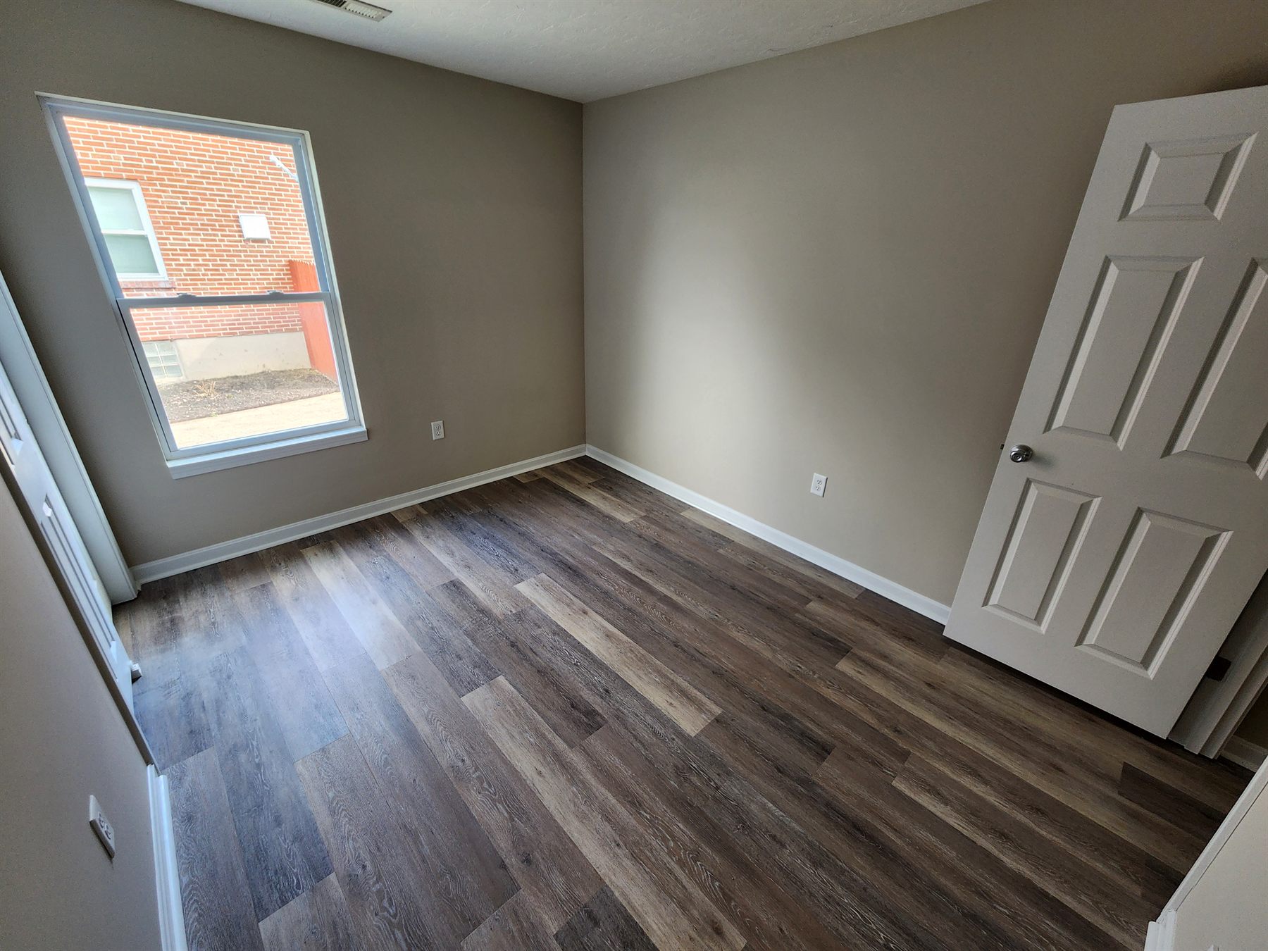 Finished bedroom showing clean walls, trim, and flooring